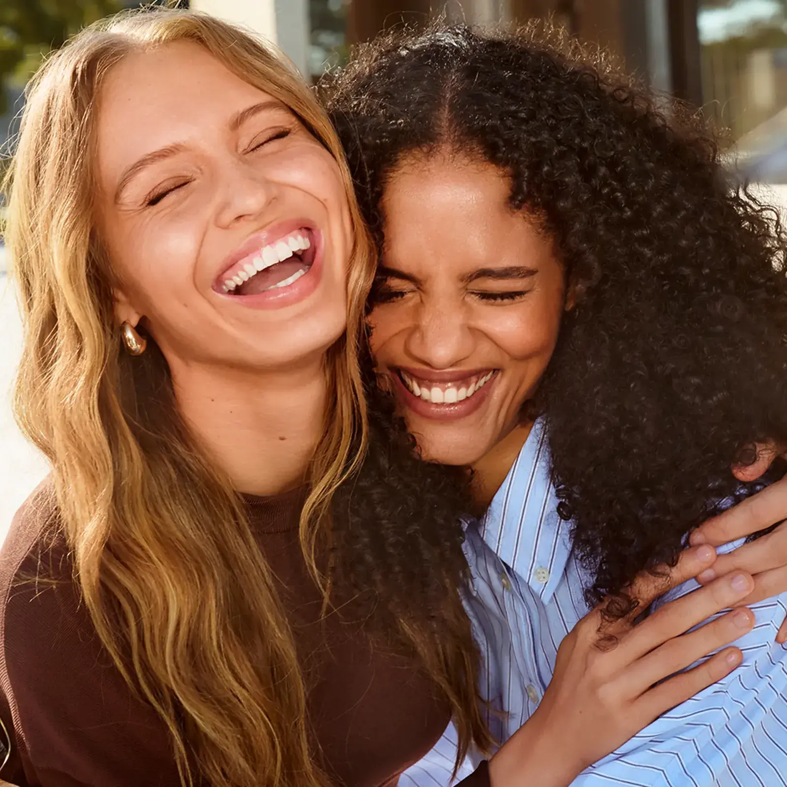 Dos amigas abrazadas riendo